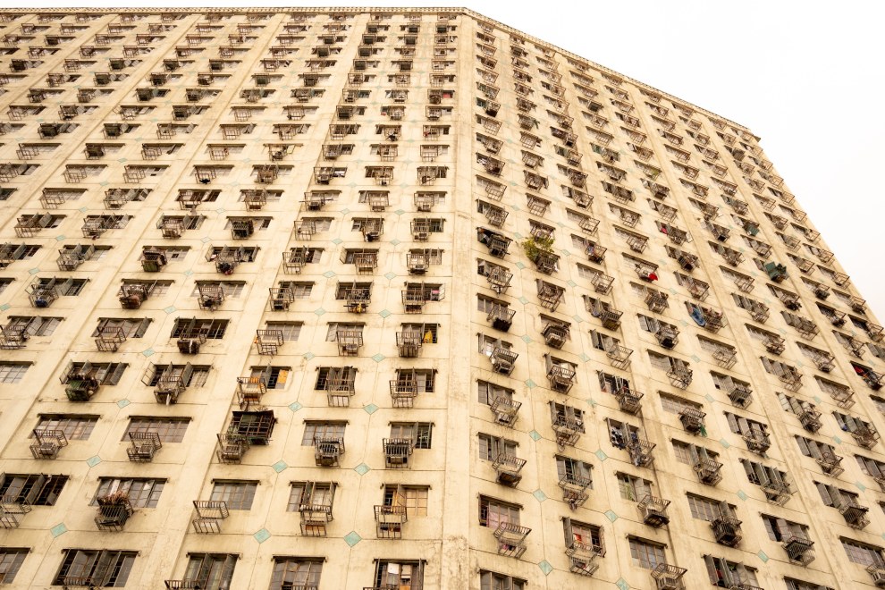 Repetitive facade of a high-rise residential building against a white sky, Manila, Philippines