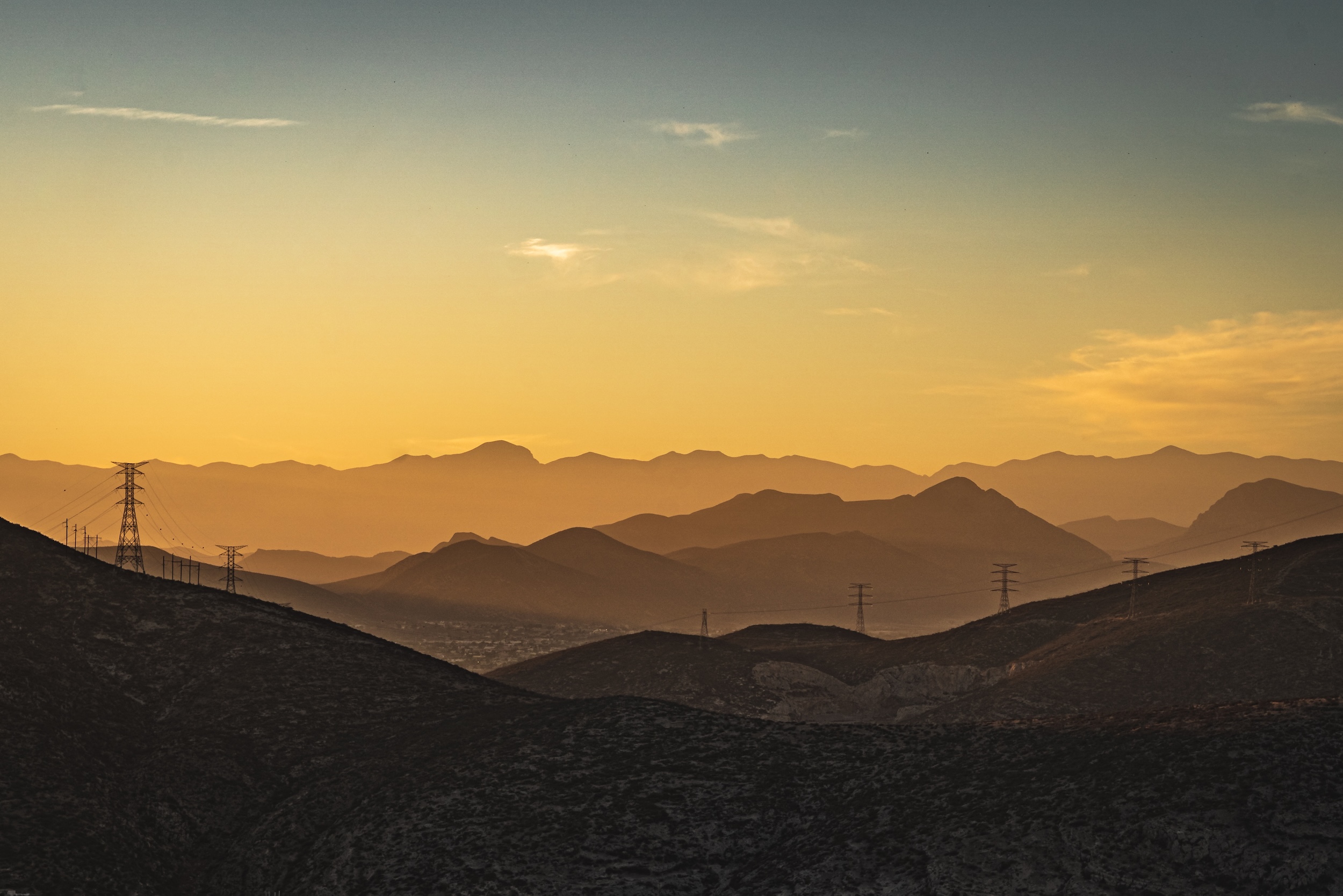 Layered mountain ridges and power pylons at sunset, Cuauhtémoc, Mexico