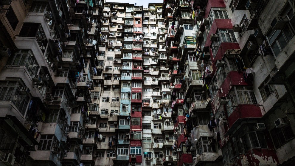 Massive residential high-rise blocks with countless balconies, seen from a courtyard in Hong Kong