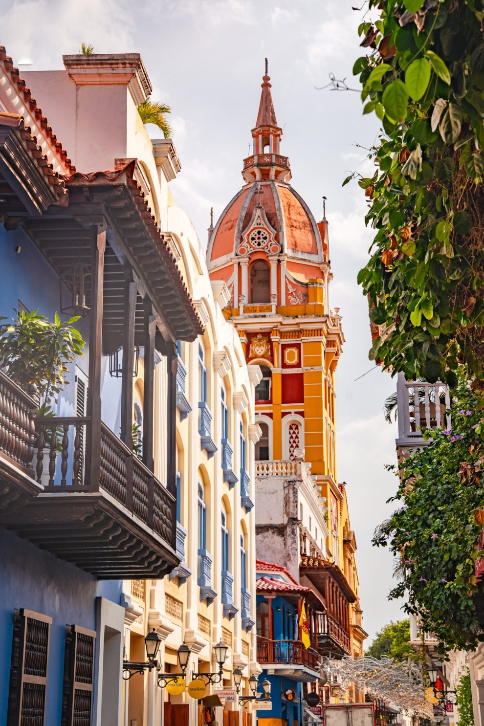 Ornate cathedral tower in red and yellow above colonial balconies in Cartagena, Colombia