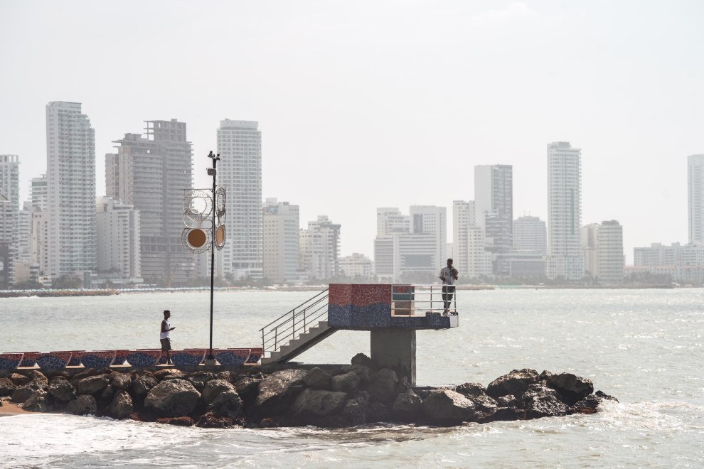 Small jetty with a diving platform in front of the hazy high-rise skyline of Cartagena, Colombia