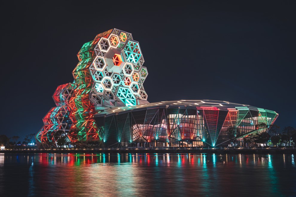 Kaohsiung Music Center illuminated in colourful lights and reflected in the water at night, Taiwan