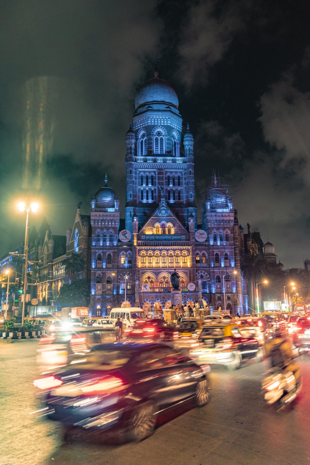Illuminated Gothic BMC building at night with blurred traffic in the foreground, Mumbai, India