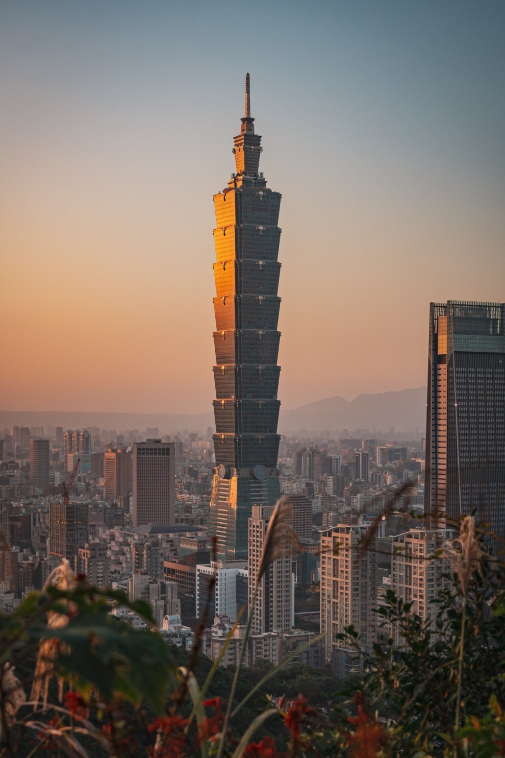 Taipei 101 rising above the city skyline in the warm evening haze, Taipei, Taiwan