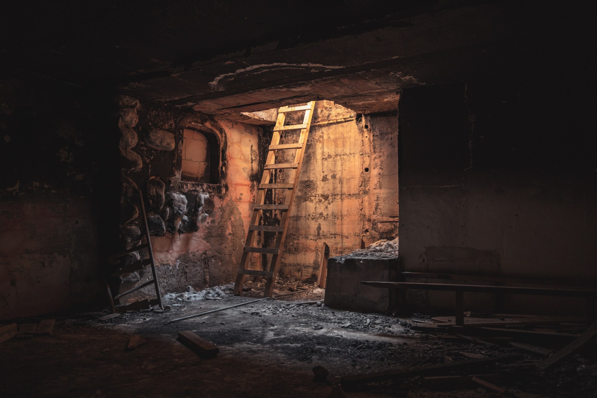 Dark room with a wooden ladder leading up into warm light, Rinella Movie Park, Malta