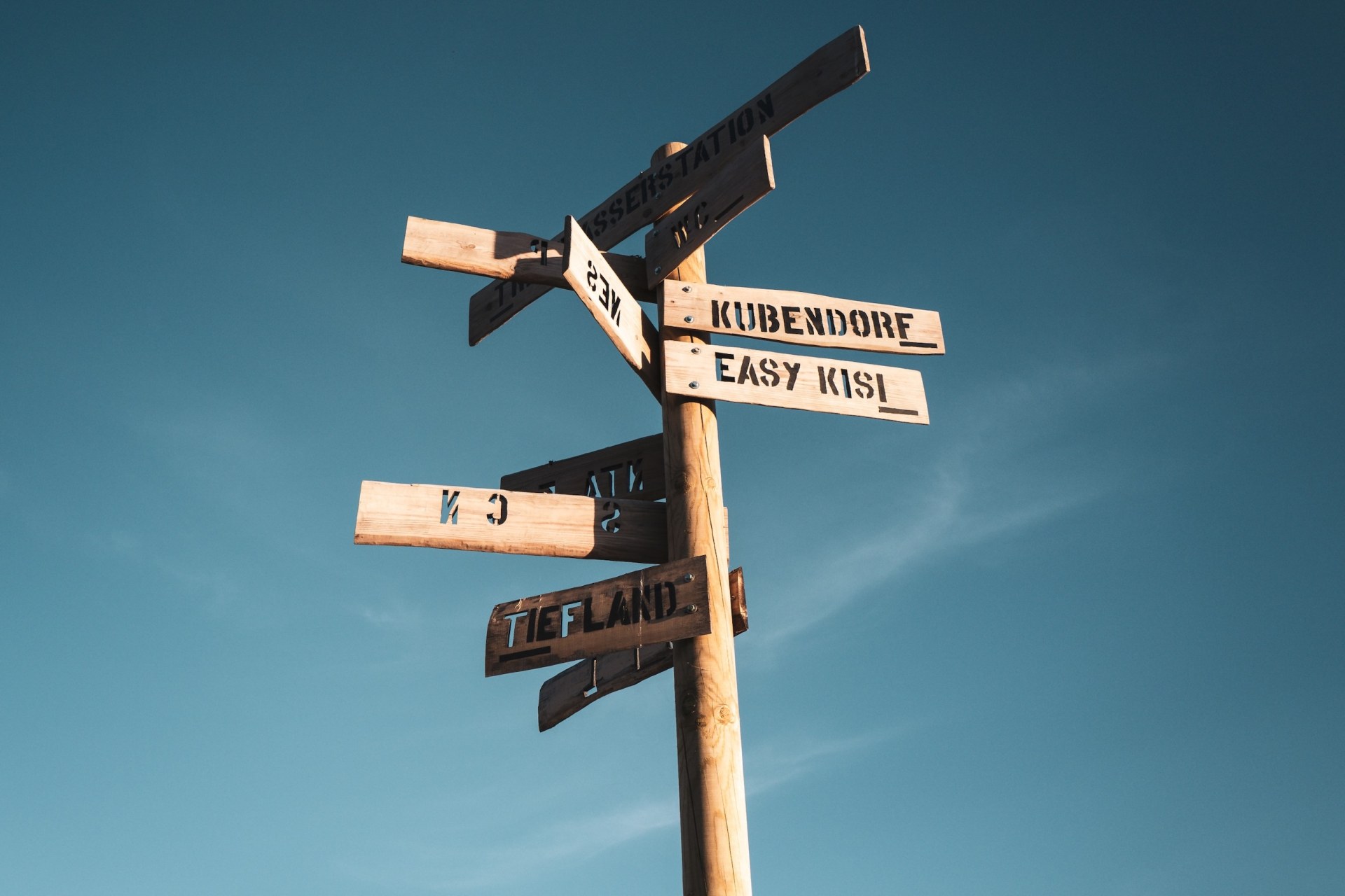 Wooden signpost with arrows pointing to festival areas against a blue sky at the deserted MS Dockville festival site, Hamburg-Wilhelmsburg, Germany, summer 2020