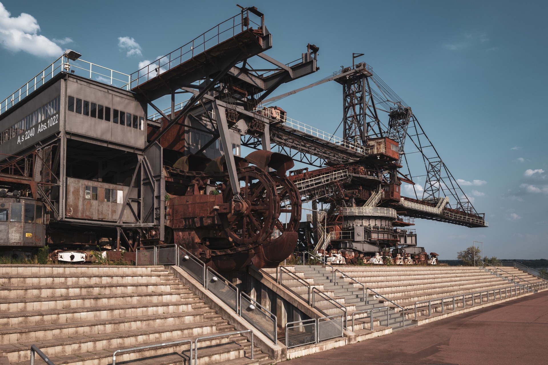 Empty grandstand in front of giant mining excavators at a deserted festival venue, Ferropolis, Gräfenhainichen, Germany, summer 2020