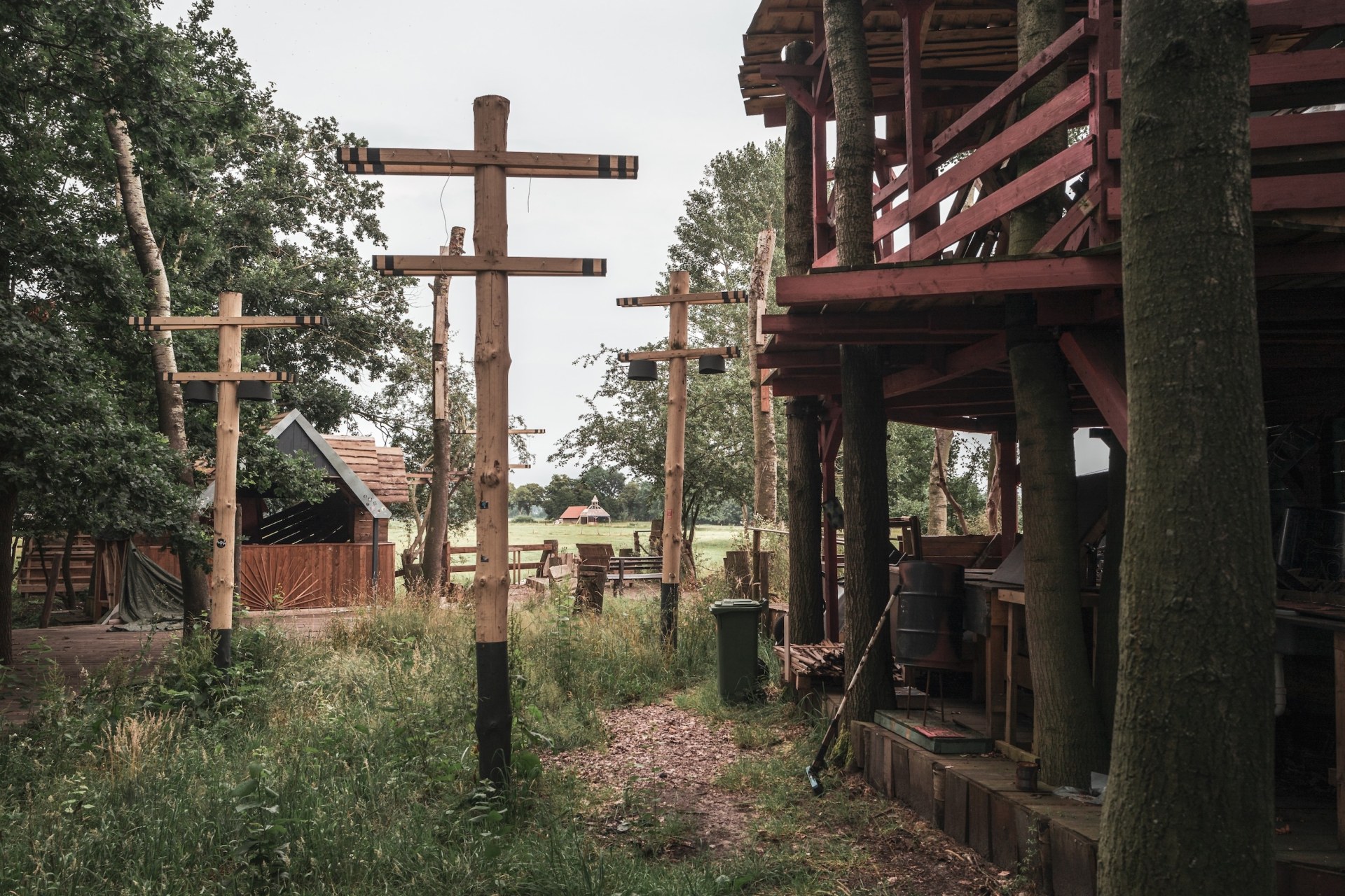 Wooden poles with crossbars and a red tree house on the deserted MOYN festival site, near Oyten, Germany, summer 2020