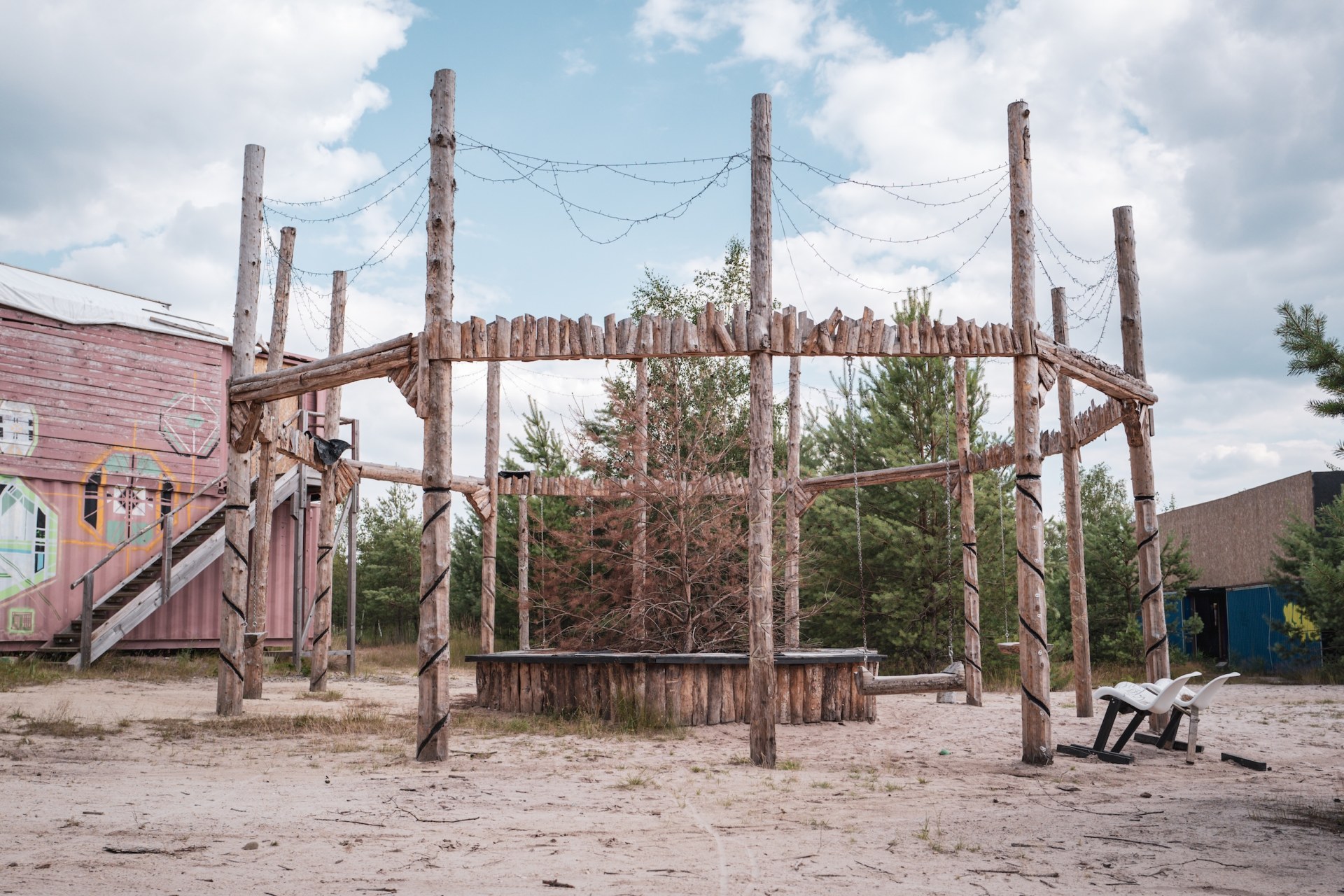 Wooden pole structure with swings in the sand of the empty Feel festival area, Bergheider See, Germany, summer 2020